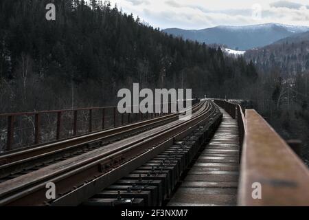 Pont ferroviaire entre les montagnes enneigées. Voyages. Transport. Banque D'Images