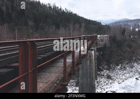 Pont ferroviaire entre les montagnes enneigées. Voyages. Transport. Banque D'Images
