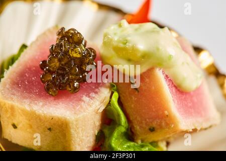 Close up of rare avec des tranches de thon ahi grillé salade de légumes frais dans une assiette. Shallow dof Banque D'Images