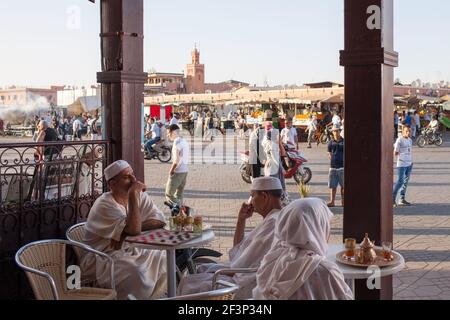 Deux hommes jouant des dames jouent dans un café devant la place du marché Jamaa El Fna (également Jemaa el-Fnaa) à Marrakech, au Maroc Banque D'Images