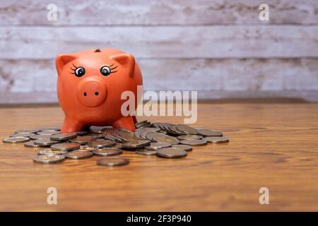 foyer sélectif d'un cochon en céramique rose pour économiser placé sur les pièces de la table avec l'espace de copie dans le concept de l'économie financière Banque D'Images