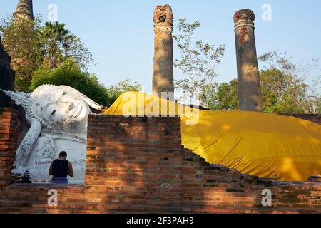 Femme bouddhiste et statue de Bouddha couché à Wat Yai Chai Mongkol, Ayutthaya, Thaïlande Banque D'Images