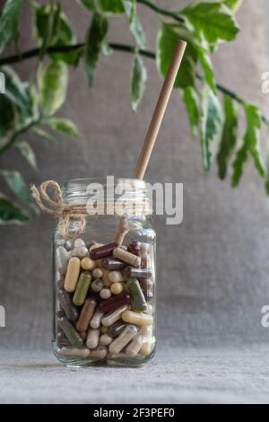 Cocktail de capsules avec des compléments alimentaires organiques à base de plantes et de minéraux dans un pot en verre. Vitamines et bioadditifs Banque D'Images