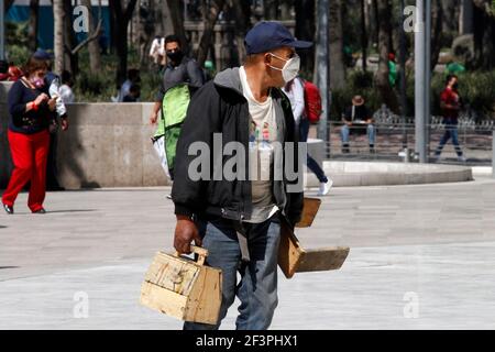 Non exclusif: MEXICO, MEXIQUE MARS 17: Un polisseur porte un masque tout en cherchant des clients à Bellas Artes Palace pendant la nouvelle normalité. Banque D'Images