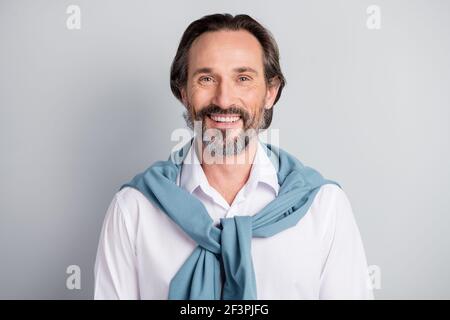 Photo de l'élégant homme confiant âge porter blanc chemise chandail épaules souriantes arrière-plan gris isolé Banque D'Images