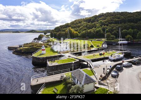 Un yacht utilisant l'écluse de mer pour entrer dans le bassin du canal sur le canal de Crinan à Crinan, Knapdale, Argyll & Bute, Écosse Royaume-Uni Banque D'Images