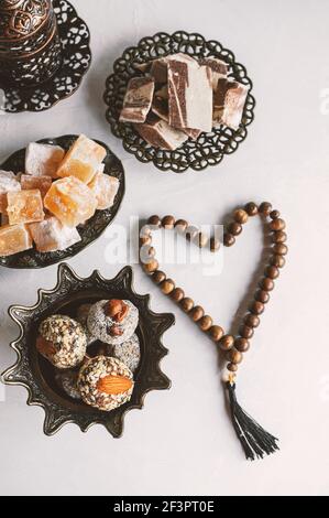 Bol avec divers morceaux de locum délice turc et thé noir à la menthe sur un fond clair. Bonbons orientaux. Espace réservé aux copies. Vue de dessus. Banque D'Images