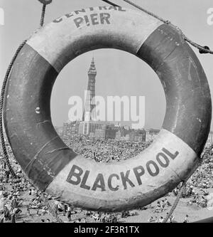 BLACKPOOL, Lancashire. Vue générale le long de la plage vers la tour Blackpool vue à travers le centre de la bouée de l'anneau de vie sur la jetée centrale. Milieu du XXe siècle Banque D'Images