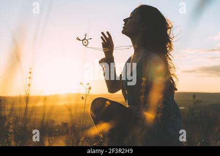 Portrait d'une jeune femme au coucher du soleil avec de beaux balinais collier de géométrie sacrée en mouvement Banque D'Images
