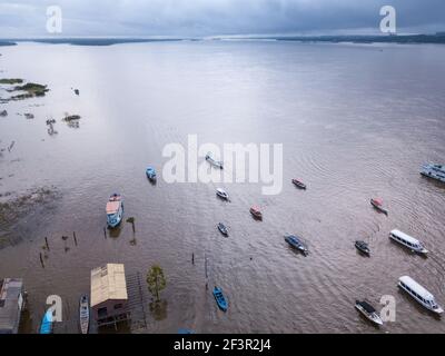 Vue aérienne drone de bateaux et maison communautaire, rivière Tapajos le jour d'hiver nuageux dans la forêt amazonienne. Itaituba, Para, Brésil. Concept d'écologie. Banque D'Images