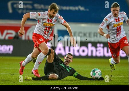 Ratisbonne, Allemagne. 17 mars 2021. Football : 2. Bundesliga, Jahn Regensburg - SpVgg Greuther Fürth, Matchday 25. Branimir Hrgota de Fürth (ci-dessous) et Benedikt Gimber de Regensburg se battent pour le ballon. Crédit : Armin Weigel/dpa - REMARQUE IMPORTANTE : Conformément aux règlements de la DFL Deutsche Fußball Liga et/ou de la DFB Deutscher Fußball-Bund, il est interdit d'utiliser ou d'avoir utilisé des photos prises dans le stade et/ou du match sous forme de séquences et/ou de séries de photos de type vidéo./dpa/Alay Live News Banque D'Images