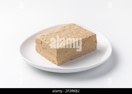 Halva gros plan sur une plaque lumineuse isolée sur un fond blanc. Vue latérale. Banque D'Images