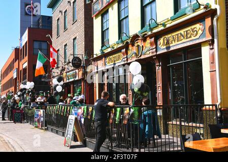 Ottawa, Canada - le 17 mars 2021 : une foule beaucoup plus petite que d'habitude, en raison des restrictions de Covid-19, célèbre la Saint-Patrick au populaire Irish Pub The Irish Village. Par temps chaud, il était possible de s'asseoir dans le patio. Banque D'Images