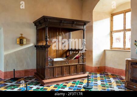 Intérieur de la résidence du duc du château de Bauska avec sol coloré et ancien lit d'essai en bois sculpté Banque D'Images