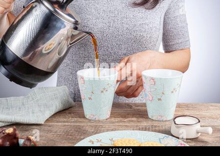 un concept de temps de thé ou de café avec des biscuits sandwich, des barres de chocolat et une tasse en céramique esthétique ainsi qu'un mini-pichet de crème sur la lune Banque D'Images