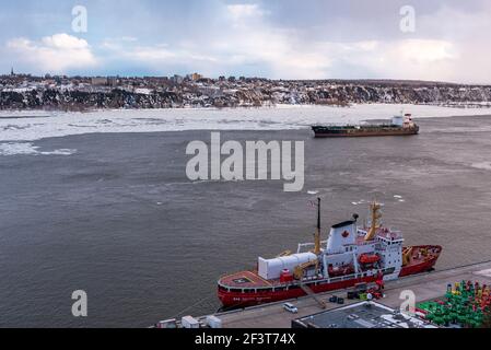 Québec, Québec, Canada – 14 mars 2021 : au coucher du soleil, vue d'hiver du trafic maritime sur le fleuve Saint-Laurent en face de la ville de Québec. Banque D'Images