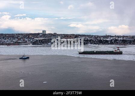 Québec, Québec, Canada – 14 mars 2021 : au coucher du soleil, vue d'hiver du trafic maritime sur le fleuve Saint-Laurent en face de la ville de Québec. Banque D'Images