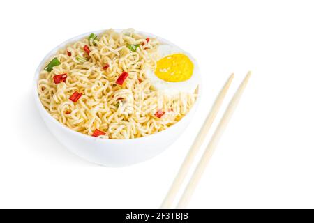 Instant noodles with vegetables and herbs in bowl isolated on white. Banque D'Images