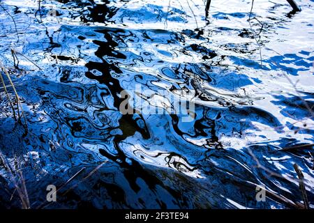 Poznan, Wielkopolska, Pologne. 17 mars 2021. Le ciel de mars se reflète dans les eaux ondulées du lac Rusalka. Dans l'image: Le motif noir sur l'eau est reflété les branches de l'arbre. Credit: Dawid Tatarkiewicz/ZUMA Wire/Alay Live News Banque D'Images