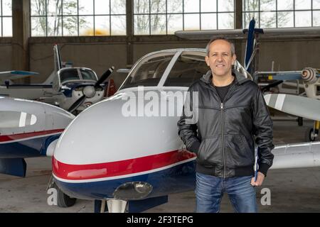 Pilote confiant tenant le presse-papiers et regardant la caméra. L'instructeur de vol passe en revue une liste de contrôle du pilote avant le vol. Banque D'Images