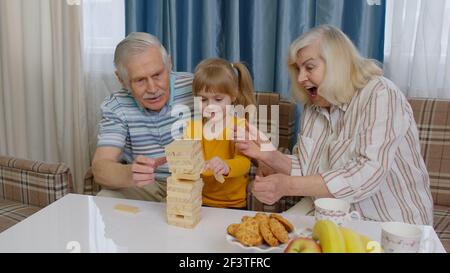 Couple senior grands-parents et petite-fille appréciant tour de construction de jeux de société à quelques centaines de mètres de chez vous Banque D'Images