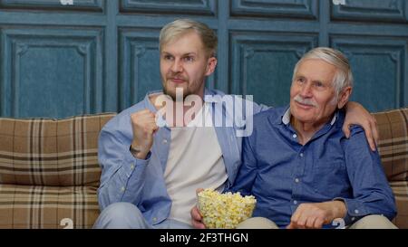 Grand-père senior et jeunes hommes regardant un match de football à la télévision, famille de génération masculine Banque D'Images