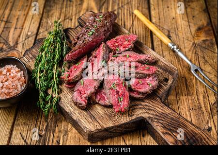 Jupe de machette grillée en tranches de bœuf à la viande sur une planche à découper en bois. fond en bois. Vue de dessus Banque D'Images