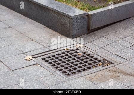 grille de drainage carrée de l'infrastructure urbaine pour piétons tapis de sol sale système de drainage d'orage avec bordure en granit de près, personne. Banque D'Images