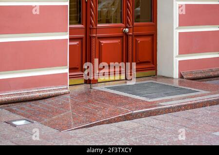 porte composite en bois avec verre, entrée de bâtiment avec seuil avec une montée de rampe et tapis de pied de façade rétro de style européen architecture, personne. Banque D'Images