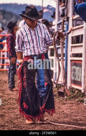Un cow-boy qui se dispute une course de taureaux porte son corsage de taureaux en préparation pour la course dans un petit rodéo au Nouveau-Mexique. Banque D'Images