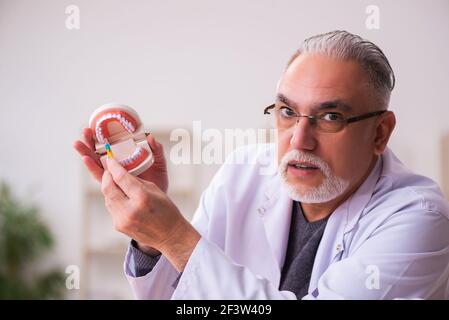 Ancien professeur de dentiste assis dans la salle de classe Banque D'Images