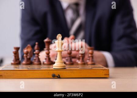 Un vieux employé d'homme d'affaires jouant aux échecs sur le lieu de travail Banque D'Images