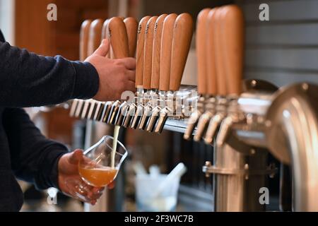 New York, États-Unis. 17 mars 2021. Un barman Torch & Crown Brewing Company verse une bière pour un patron car les restaurants seront autorisés à augmenter la capacité de restauration intérieure de 35 % à 50 % le 19 mars, New York, NY, 17 mars 2021. Torch & Crown Brewing Company est l'une des 39 brasseries de New York, mais la seule de Manhattan. (Photo par Anthony Behar/Sipa USA) crédit: SIPA USA/Alay Live News Banque D'Images