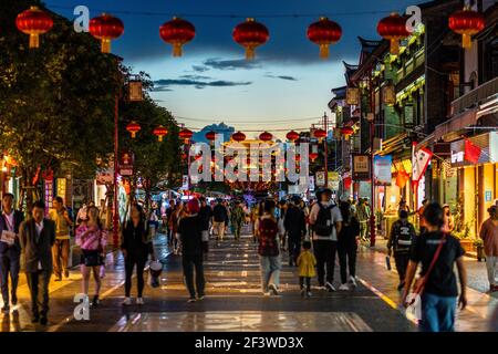 Kunming China , 4 octobre 2020 : belle vue sur la rue de la ville ancienne de Guandu pleine de personnes avec des lanternes chinoises et porte principale à distance la nuit Banque D'Images