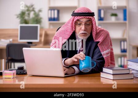 Un employé arabe âgé boit du café pendant la pause Banque D'Images