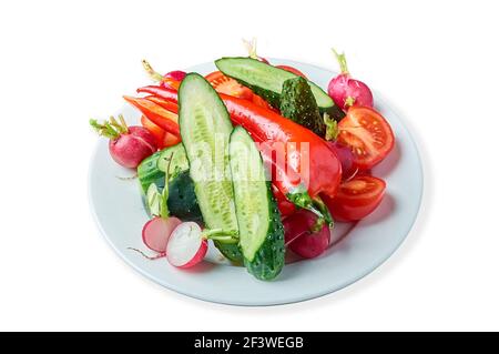 trancher des légumes frais sur une assiette sur fond blanc Banque D'Images