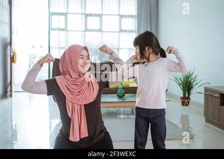 femme musulmane faisant du sport et de l'exercice avec sa fille à la maison Banque D'Images