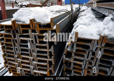 le métal roulé se trouve dans la rue sous la neige. Banque D'Images