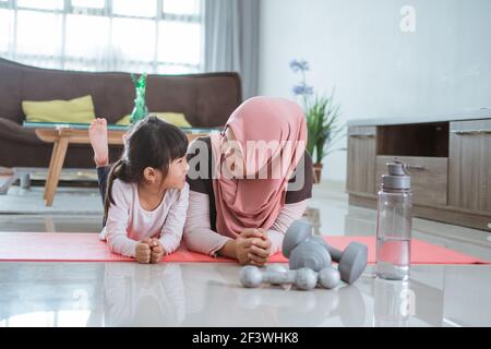 femme musulmane faisant du sport et de l'exercice avec sa fille à la maison Banque D'Images