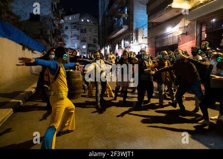 Les jeunes Israéliens dansent à la musique écoutés à l'aide d'écouteurs sans fil dans une soirée disco silencieuse dans la zone à la mode derrière le marché de Mahane ou de Machane Yehuda souvent appelé « le Shuk » à Jérusalem-Ouest, en Israël Banque D'Images