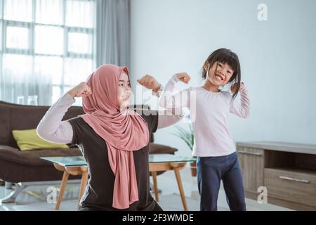 femme musulmane faisant du sport et de l'exercice avec sa fille à la maison Banque D'Images