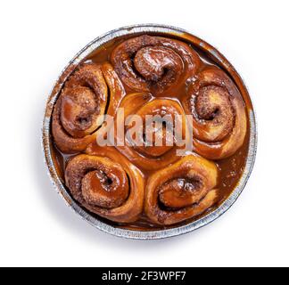 petits pains à la cannelle fraîchement cuits recouverts de sauce caramel isolés sur fond blanc, vue de dessus Banque D'Images