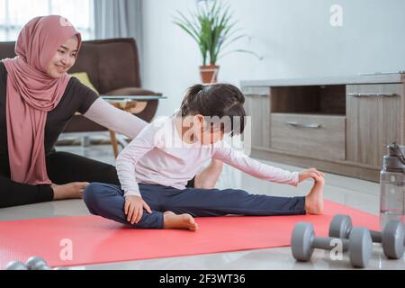 femme musulmane faisant du sport et de l'exercice avec sa fille à la maison Banque D'Images