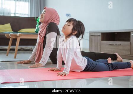 femme musulmane faisant du sport et de l'exercice avec sa fille à la maison Banque D'Images