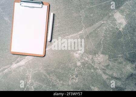 Espace de travail féminin avec bloc-notes, presse-papiers, papier sur fond de marbre avec espace de copie. Vue de dessus, espace de copie. Blogueur, concept d'entreprise féminine Banque D'Images