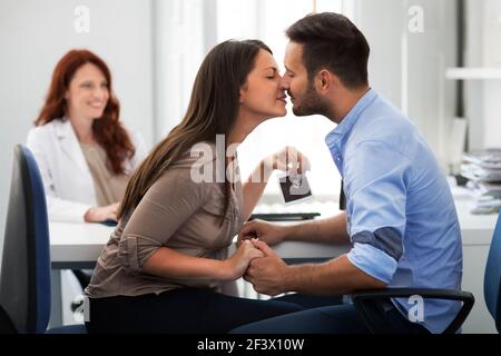 Bonne mère tenant l'échographie et baiser mari à un ginecologist clinique Banque D'Images