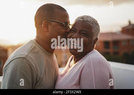 Couple africain heureux ayant un moment tendre à l'extérieur au coucher du soleil d'été - Focus sur le visage de la femme Banque D'Images