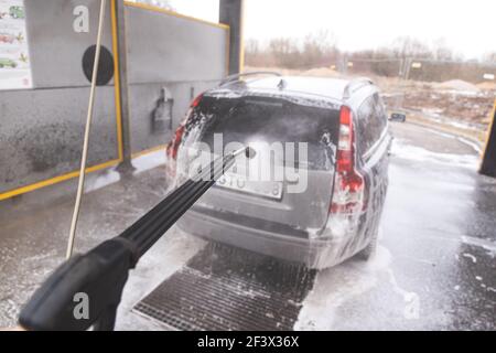 Système de lavage de voiture en libre-service sans contact. Laver la voiture sale dans le poste de lavage de voiture avec de la mousse Banque D'Images