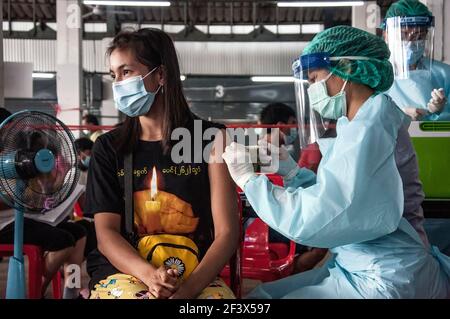 Une femme portant un masque facial reçoit le vaccin Sinovac COVID-19 lors d'une inoculation massive du vaccin. L'Administration métropolitaine de Bangkok commence l'inoculation massive du vaccin Sinovac COVID-19 pour les résidents locaux du district de Bang Khae à la suite d'une nouvelle grappe de coronavirus (Covid-19) détectée sur le marché de Bang Khae. (Photo de Peerapon Boonyakiat / SOPA image/Sipa USA) Banque D'Images