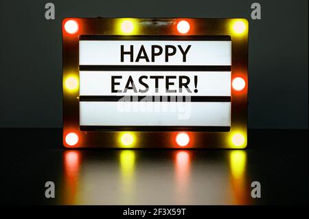 Visionneuse avec des lumières rouges et jaunes avec des mots - joyeuses Pâques! Banque D'Images